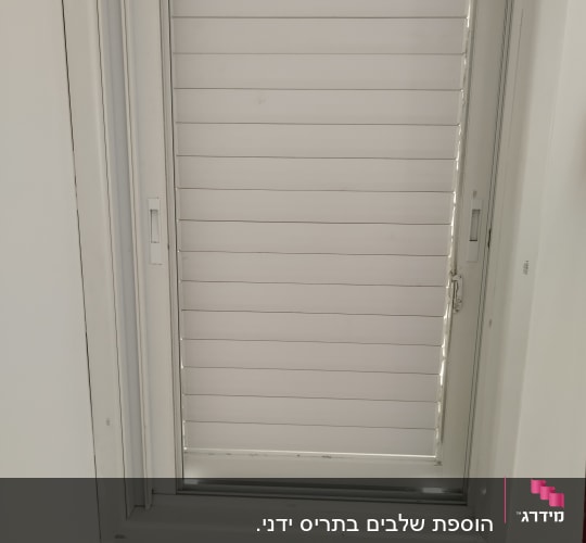תריסים לבנים סגורים בתוך מסגרת חלון לבנה